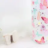 Zauberhaftes Basteln mit Servietten: Ein Glas mit bunten Schmetterlingen, kleine Lichter und eine Holzschmetterling-Deko.