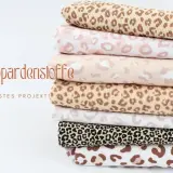 Stapel von Stoffen mit Leopardenmuster in verschiedenen Farben und Größen. Ein Stofflexikon für deine nächsten Nähprojekte.