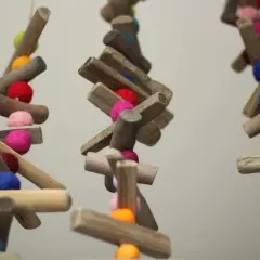 Bunte Filzkugeln und Holzstücke hängen an Schnüren. Tolle nadelfilzen ideen für Deko oder Vogelfutter.