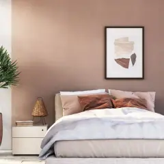 Gemütliches Schlafzimmer mit warmen Wandgestaltung Farben in Rosé- und Erdtönen. Ein Bett mit beiger Bettwäsche und braunen Kissen lädt zum Entspannen ein.