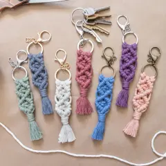 Bunte Makramee-Schlüsselanhänger mit Quasten, tolle Makramee-Ideen für DIY-Projekte. Dazu eine Schere, Garnrolle und Schlüssel.