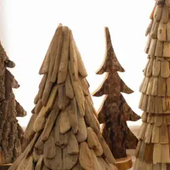 Rustikale Weihnachtsdeko Holz selber machen: Vier handgefertigte Bäume aus Holzstücken und Rinde, die an Tannen erinnern.