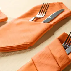 Orange Stoffservietten mit bestercktasche falten papier vorlage. Gedeckter Tisch für ein Festessen.