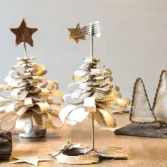 Deko basteln mit alten Buchseiten: Kleine, handgefertigte Weihnachtsbäume aus Papier, verziert mit Sternen.