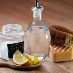 Natürliche Reinigungsmittel: Natron, Zitrone und Essigreiniger-Flasche mit Bürste und Schwamm.