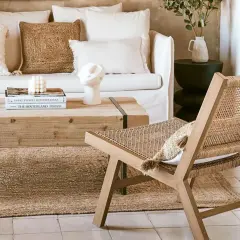 Gemütliches Wohnzimmer im Boho-Stil mit Rattan-Stuhl, Naturmaterialien und erdigen Tönen.