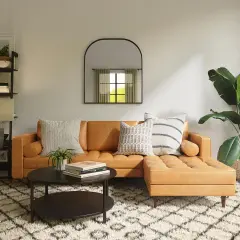Gemütliches Wohnzimmer mit cognacfarbenem Sofa, Couchtisch, Regal und Pflanzen. Tolle Einrichtung Beispiele für ein stilvolles Zuhause.