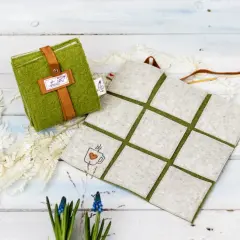 Grünes Filz-Sitzkissen mit Lederriemen und Kaffeetassen-Stickerei. Perfekt zum **sitzkissen selber machen** für gemütliche Stunden.