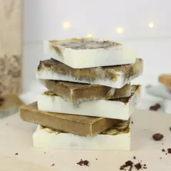 Stapel handgemachter Kaffeeseife, perfekt zum Kaffeeseife selber machen. Kaffeebohnen und Kaffeesatz deuten auf die Zutaten hin.