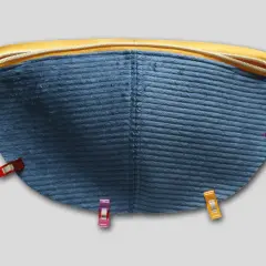 Blauer Cordstoff mit Reißverschluss und Nähklammern, bereit für das Schnittmuster einer Bauchtasche.