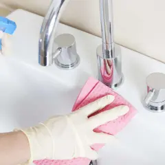Mit Handschuhen und einem selbstgemachten Badreiniger wird das Waschbecken blitzblank.