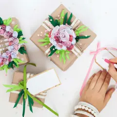 Schöne DIY-Geburtstagsgeschenke für Frauen: liebevoll verpackte Präsente mit Blumen aus Papier und handgeschriebenen Karten.