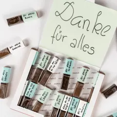 Kleine Merci-Schokoladen, liebevoll beschriftet für das Basteln zum Valentinstag. Eine süße Geste der Dankbarkeit.