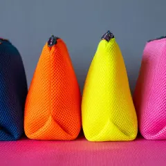 Vier bunte Netzbeutel in Blau, Orange, Gelb und Pink. Ein einfaches schnittmuster tasche, perfekt für Kosmetik oder Stifte.