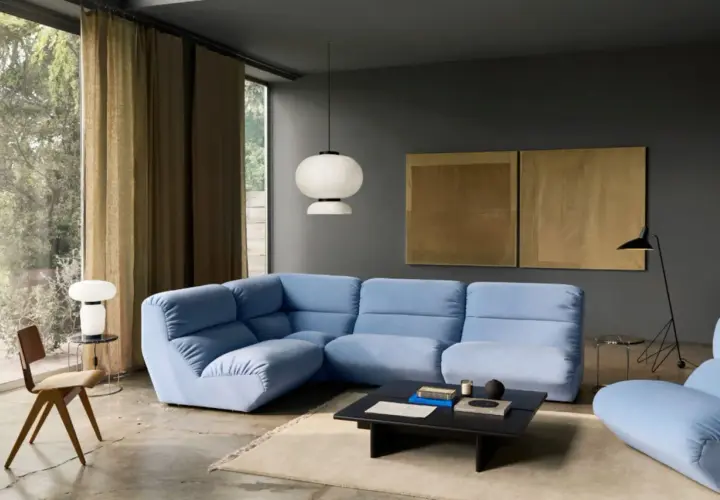 Moderne Wohnzimmer-Ideen: Hellblaues Ecksofa, dunkle Wandfarbe, goldene Kunstwerke und ein minimalistischer Stil.
