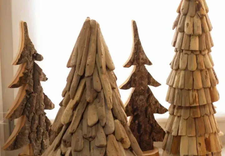 Rustikale Weihnachtsdeko Holz selber machen: Vier handgefertigte Bäume aus Holzstücken und Rinde, die an Tannen erinnern.
