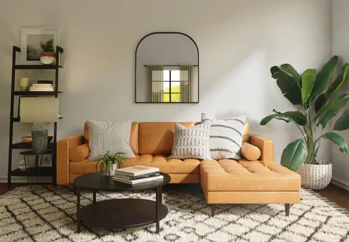 Gemütliches Wohnzimmer mit cognacfarbenem Sofa, Couchtisch, Regal und Pflanzen. Tolle Einrichtung Beispiele für ein stilvolles Zuhause.
