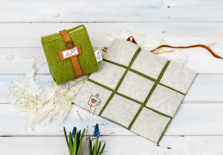 Grünes Filz-Sitzkissen mit Lederriemen und Kaffeetassen-Stickerei. Perfekt zum **sitzkissen selber machen** für gemütliche Stunden.