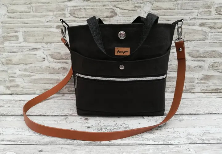 Schwarze Sling Bag mit Lederriemen. Hier findest du ein sling bag schnittmuster kostenlos zum Nachnähen.