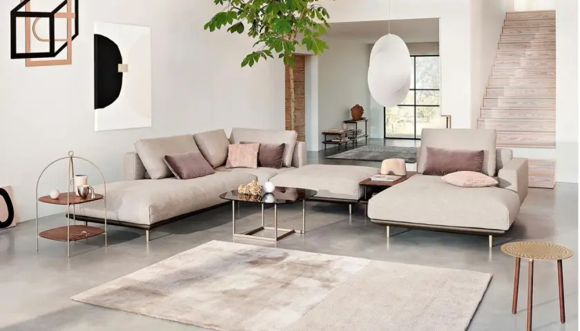Stilvolles Wohnzimmer mit beiger Couch, Kunst und Pflanzen. Tolle wohnzimmer deko ideen für ein modernes Ambiente.