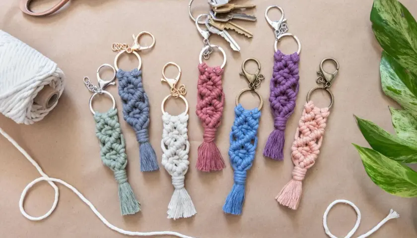 Bunte Makramee-Schlüsselanhänger mit Quasten, tolle Makramee-Ideen für DIY-Projekte. Dazu eine Schere, Garnrolle und Schlüssel.