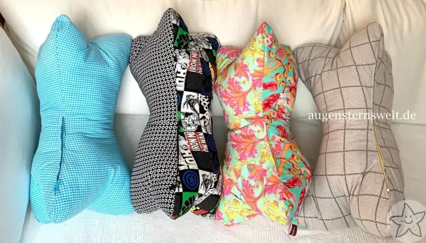 Vier bunte Leseknochen-Kissen mit verschiedenen Mustern: blau kariert, Comic-Helden, floral und kariert. Das Leseknochen Schnittmuster ist vielseitig.