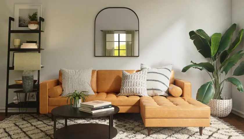 Gemütliches Wohnzimmer mit cognacfarbenem Sofa, Couchtisch, Regal und Pflanzen. Tolle Einrichtung Beispiele für ein stilvolles Zuhause.