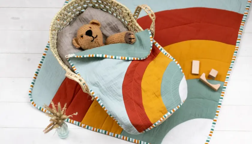 Bunte Krabbeldecke mit Tupfenmuster und süßer Applikation. Ein tolles Schnittmuster für DIY-Projekte!