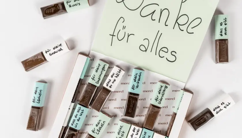 Kleine Merci-Schokoladen, liebevoll beschriftet für das Basteln zum Valentinstag. Eine süße Geste der Dankbarkeit.