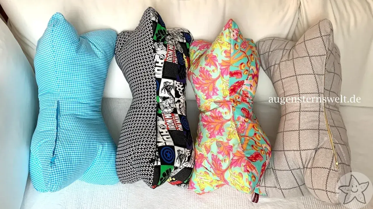 Vier bunte Leseknochen-Kissen mit verschiedenen Mustern: blau kariert, Comic-Helden, floral und kariert. Das Leseknochen Schnittmuster ist vielseitig.