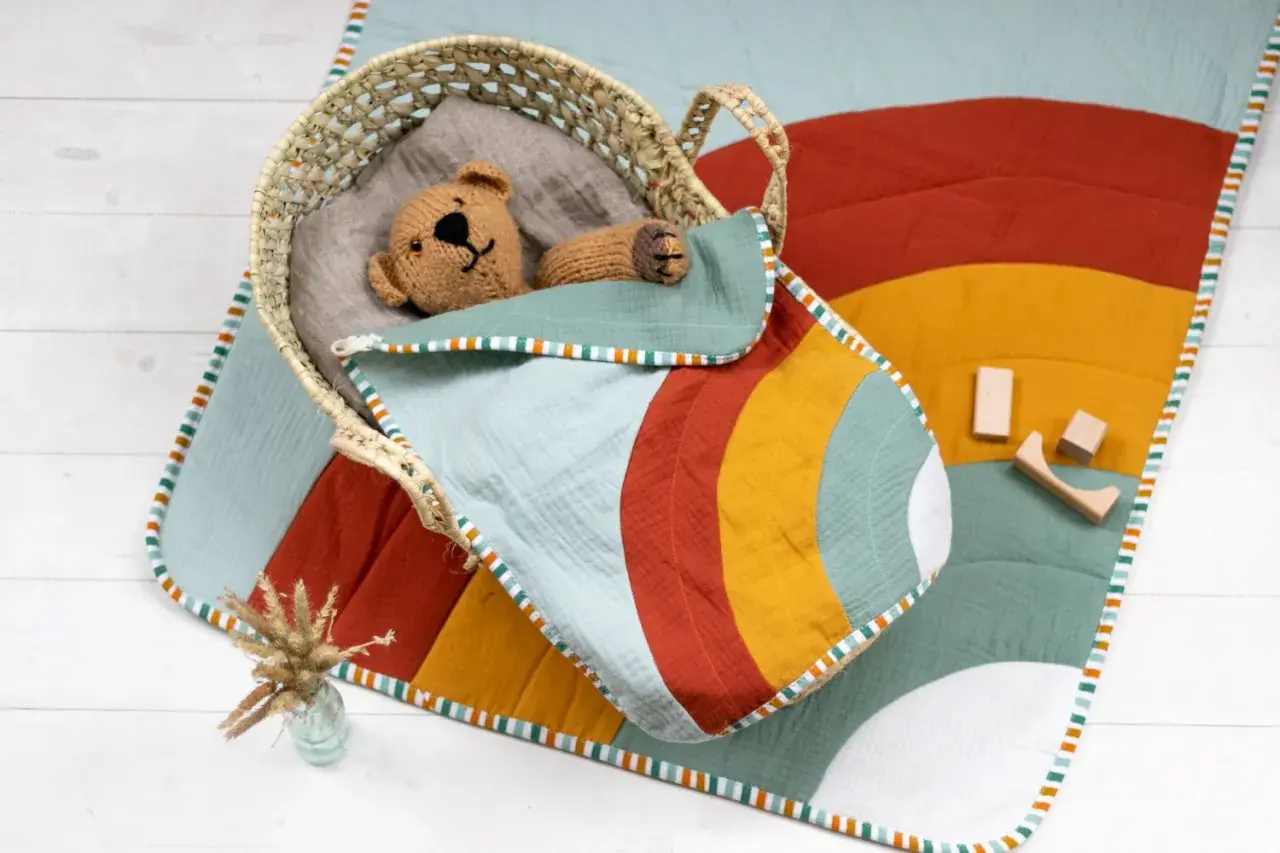 Bunte Krabbeldecke mit Tupfenmuster und süßer Applikation. Ein tolles Schnittmuster für DIY-Projekte!