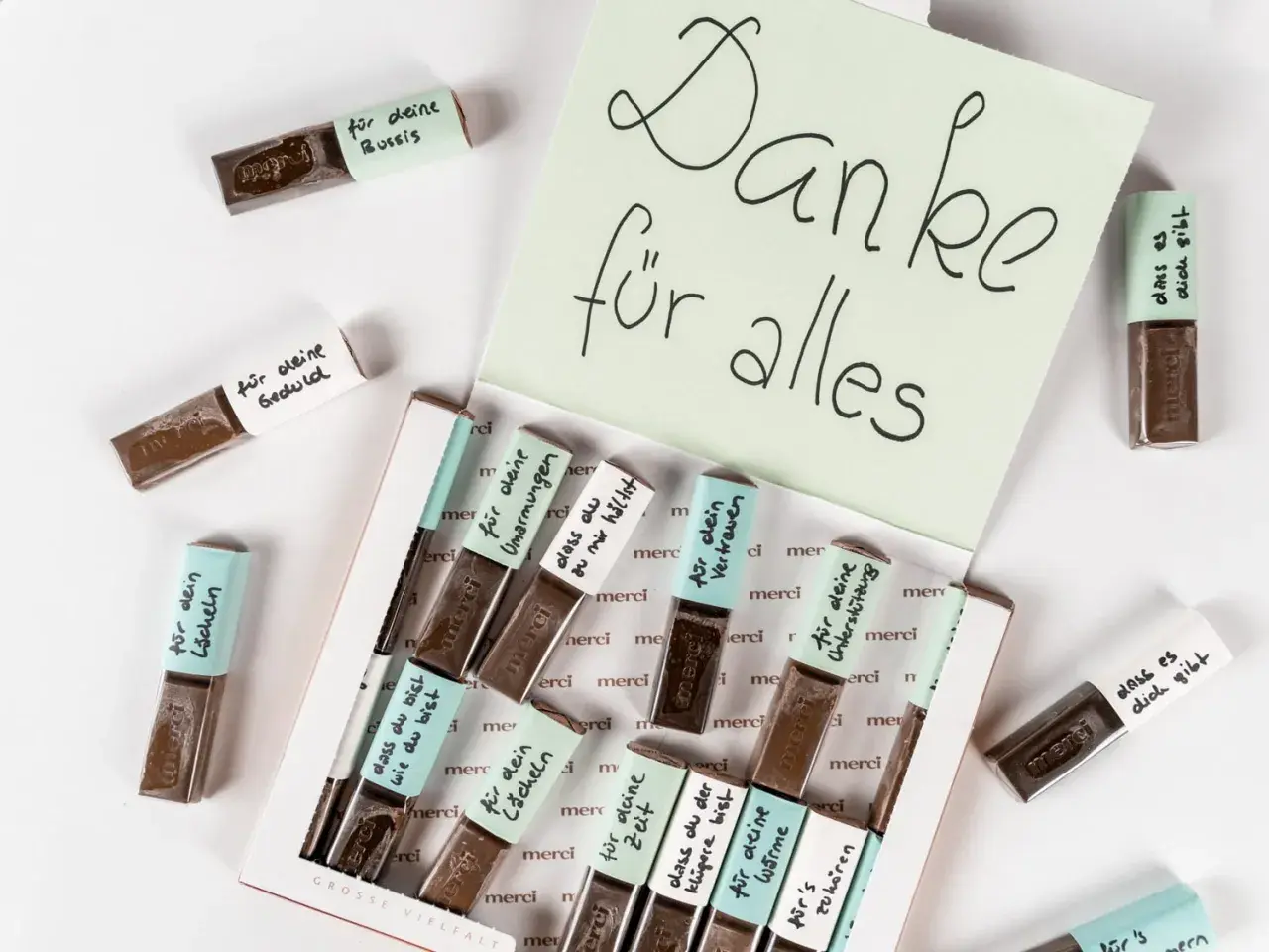 Kleine Merci-Schokoladen, liebevoll beschriftet für das Basteln zum Valentinstag. Eine süße Geste der Dankbarkeit.