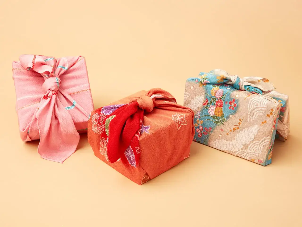 Drei Geschenke, kunstvoll in bunten Stoffen verpackt. Eine Furoshiki Anleitung zeigt, wie einfach und schön diese japanische Wickeltechnik ist.