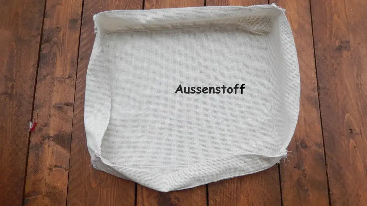 Stoff f&uuml;r ein Sitzkissen selber machen: Ein wei&szlig;er Au&szlig;enstoff liegt auf Holzbrettern.