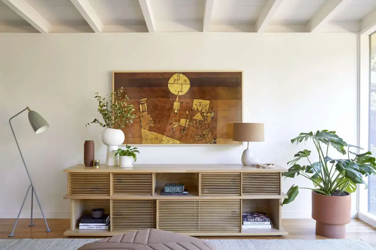 Inspiration f&uuml;r die Dekoration eines Sideboards: Ein helles Holz-Sideboard mit Lampe, Vase, Pflanzen und einem abstrakten Bild.