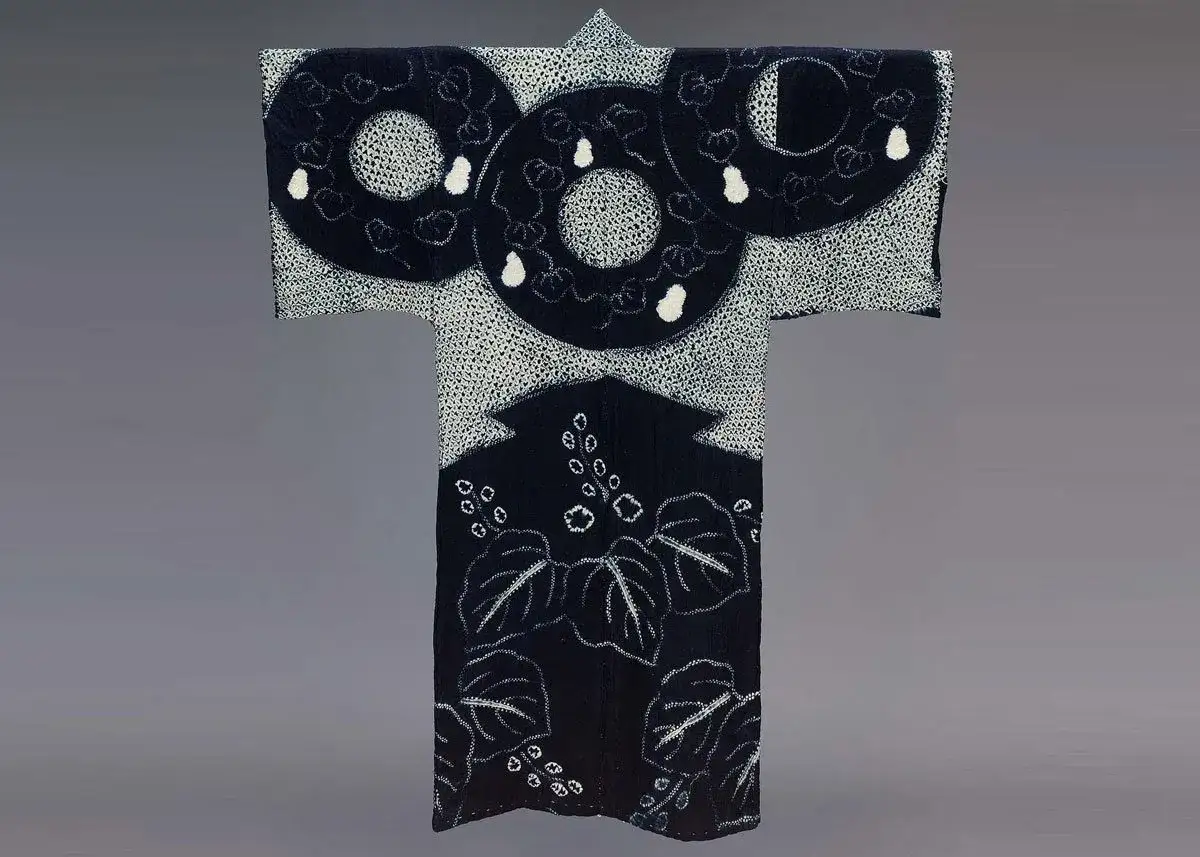 Ein dunkles Kimono mit der Shibori Technik. Gro&szlig;e Kreise mit wei&szlig;en Punkten und Bl&auml;tterprints zieren das Kleidungsst&uuml;ck.