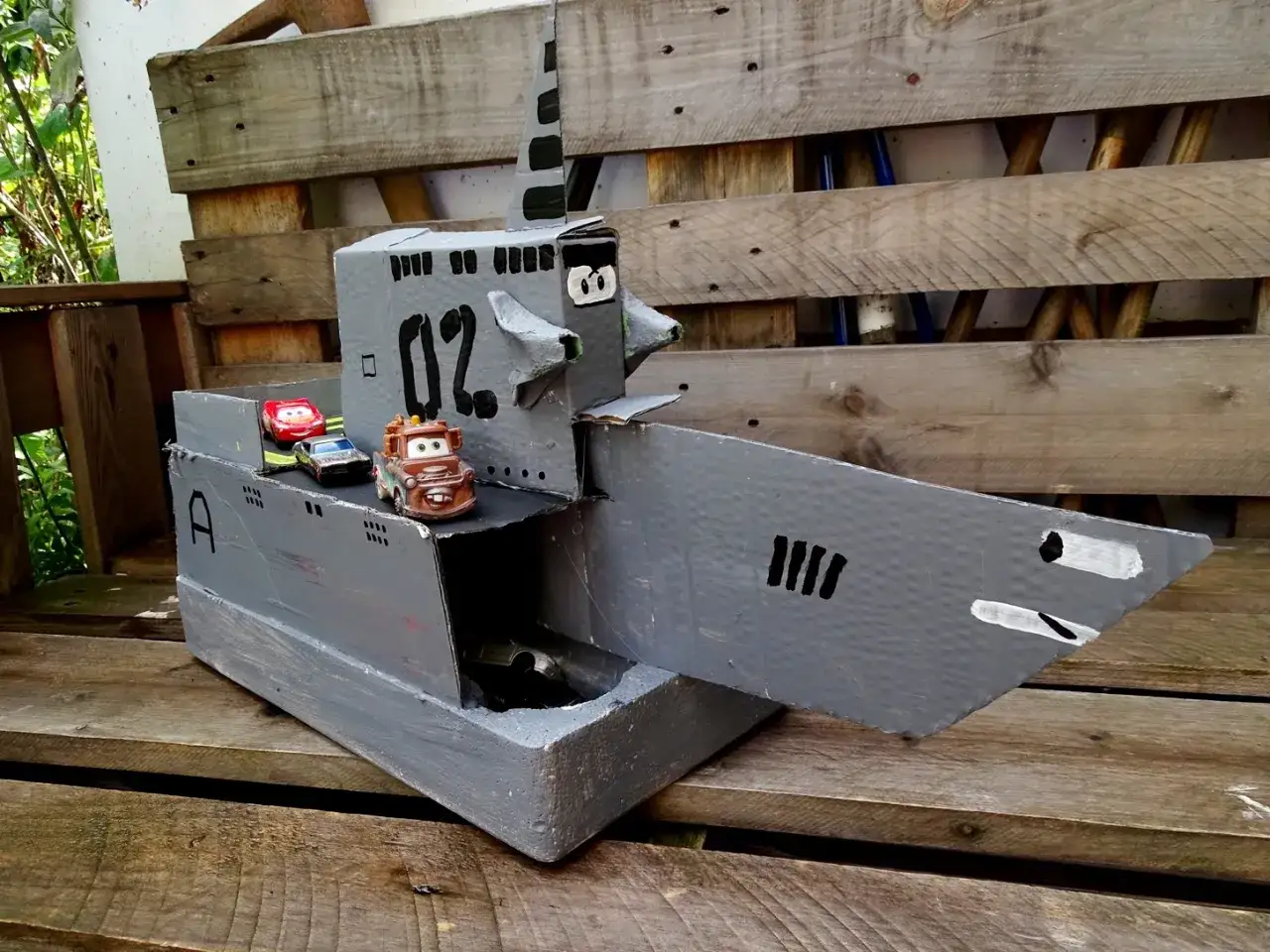 Kreative Upcycling Ideen: Ein U-Boot aus Pappe mit Spielzeugautos, das zum Spielen einlädt.
