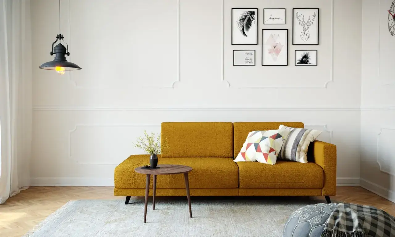 Gemütliches kleines Wohnzimmer einrichten mit senfgelbem Sofa, Kissen, Beistelltisch und Wanddeko.