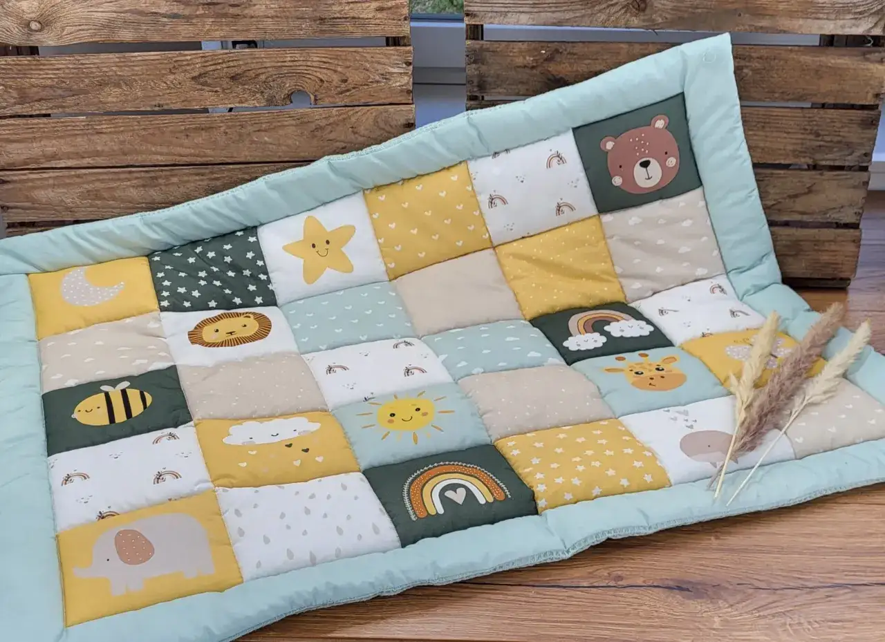 Bunte Krabbeldecke mit Tiermotiven wie Bär, Elefant, Giraffe und Sternen. Ein tolles Schnittmuster für ein Babygeschenk.