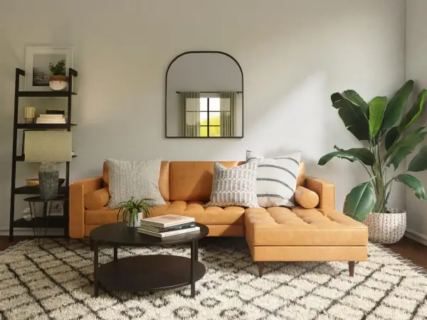 Gemütliches Wohnzimmer mit cognacfarbenem Sofa, Couchtisch, Regal und Pflanzen. Tolle Einrichtung Beispiele für ein stilvolles Zuhause.